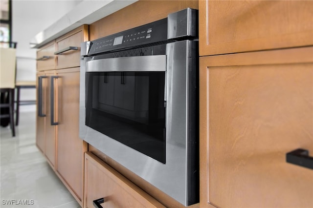 kitchen featuring stainless steel oven and light brown cabinets