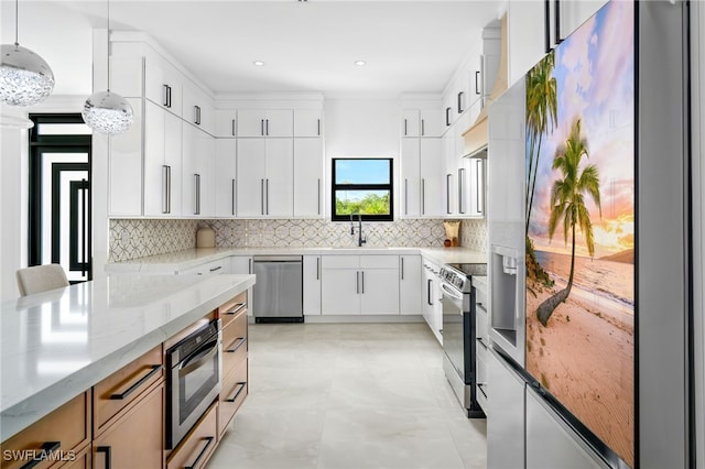 kitchen with light stone countertops, appliances with stainless steel finishes, decorative light fixtures, white cabinetry, and sink