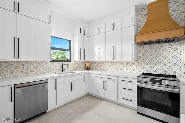 kitchen featuring custom exhaust hood, appliances with stainless steel finishes, sink, and white cabinetry