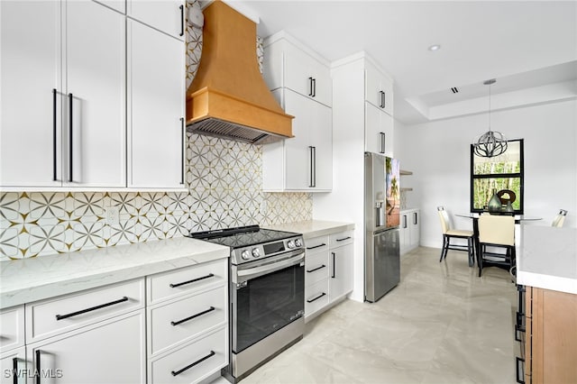 kitchen featuring premium range hood, stainless steel appliances, white cabinets, and hanging light fixtures