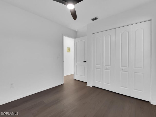 unfurnished bedroom featuring a closet, ceiling fan, and dark hardwood / wood-style floors