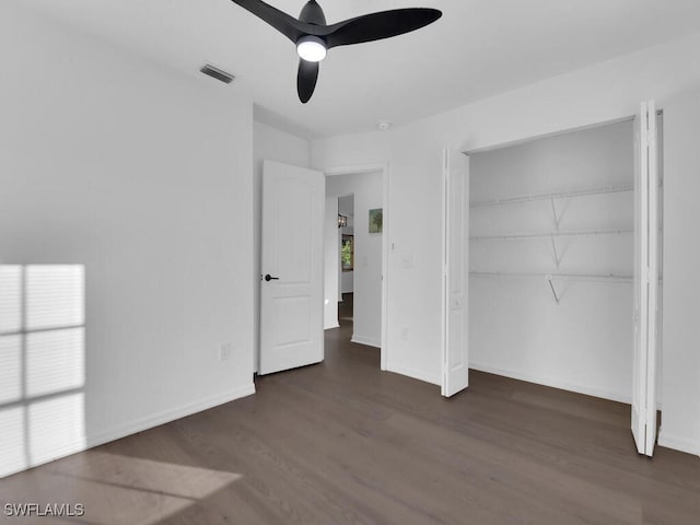 unfurnished bedroom with multiple windows, a closet, ceiling fan, and dark wood-type flooring