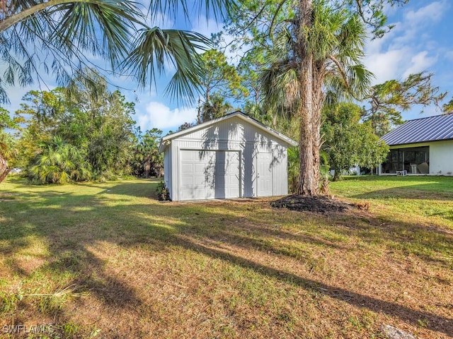 view of outdoor structure with a lawn and a garage