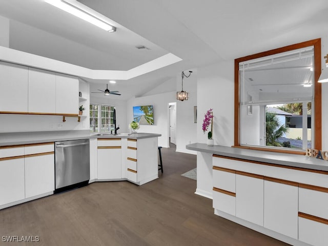 kitchen with sink, kitchen peninsula, hanging light fixtures, stainless steel dishwasher, and white cabinetry