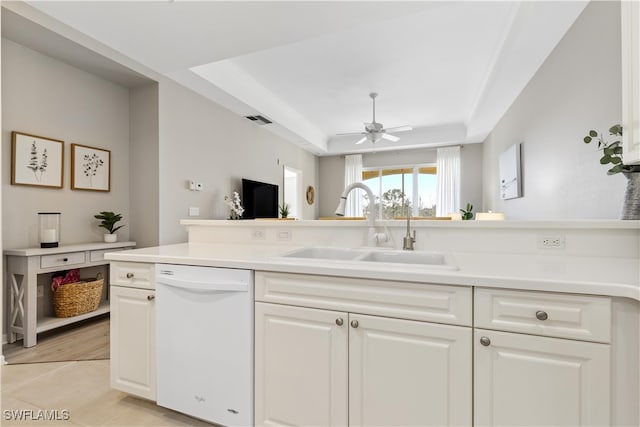 kitchen with white cabinetry, sink, white dishwasher, ceiling fan, and a raised ceiling