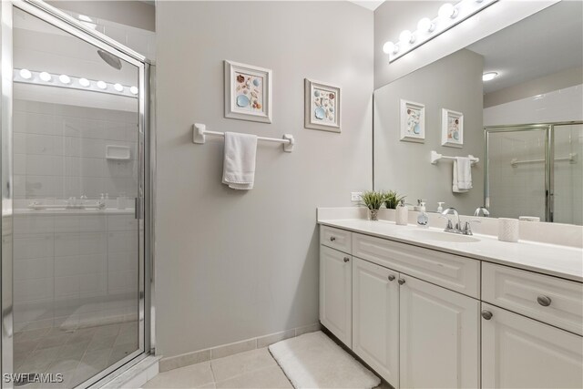 bathroom featuring vanity, a shower with door, and tile patterned flooring