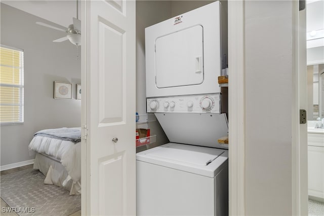 washroom with ceiling fan, tile patterned floors, and stacked washer / dryer