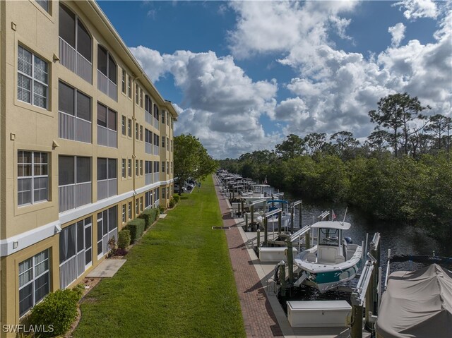 dock area with a water view and a yard