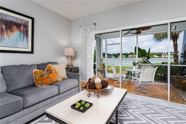 living room with light hardwood / wood-style floors, a water view, and ceiling fan