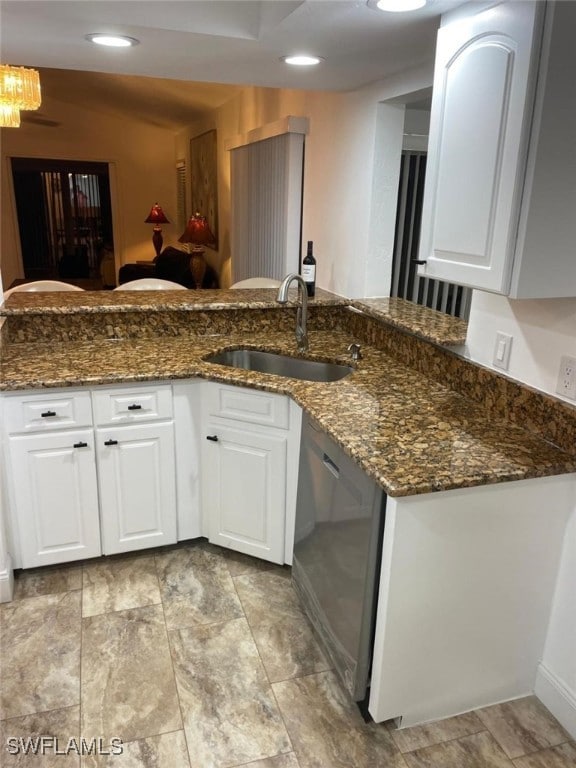 kitchen with white cabinets, dark stone countertops, sink, and dishwasher