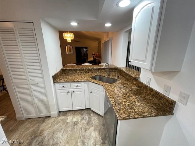 kitchen with dark stone counters, dishwasher, sink, and white cabinets