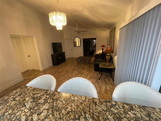 dining space with light wood-type flooring, vaulted ceiling, and ceiling fan with notable chandelier