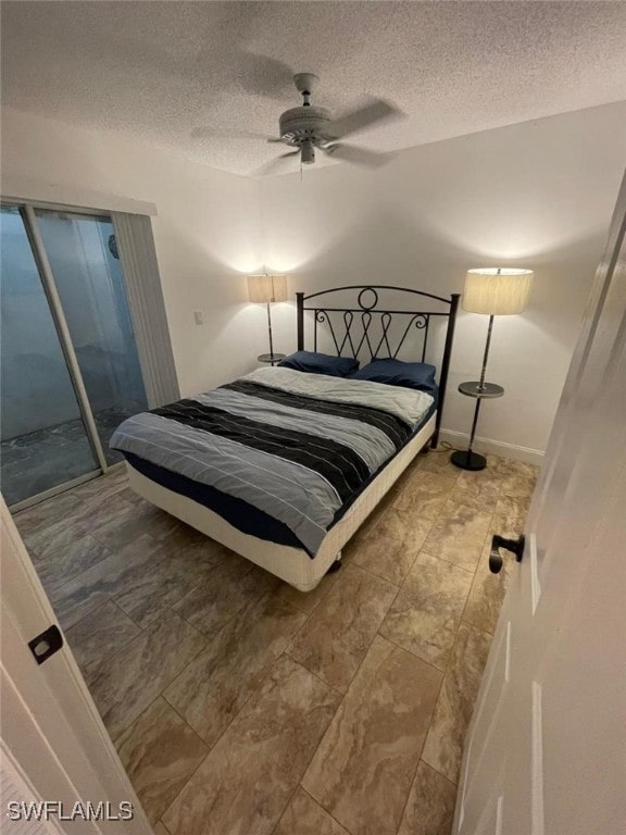 bedroom featuring ceiling fan, a textured ceiling, and access to exterior