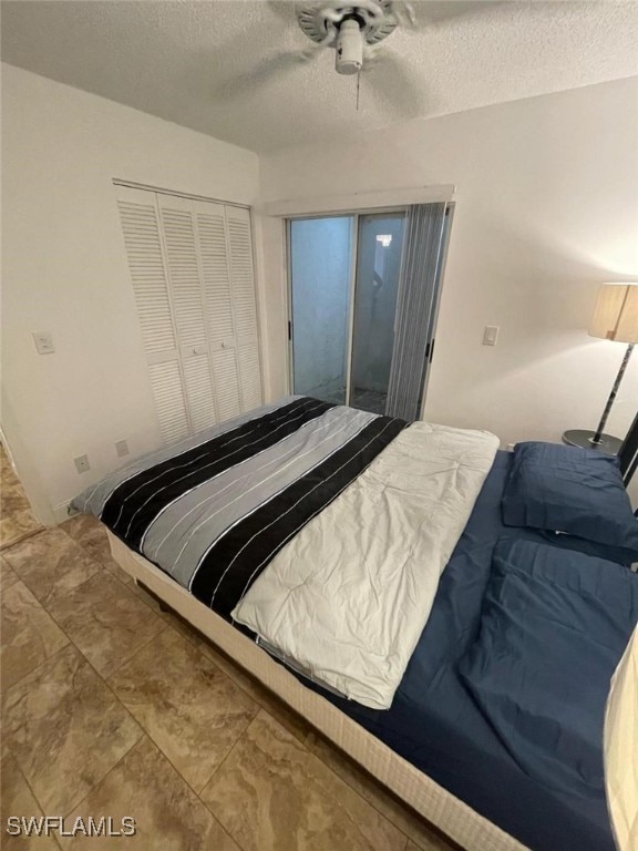 bedroom with a closet, a textured ceiling, and ceiling fan