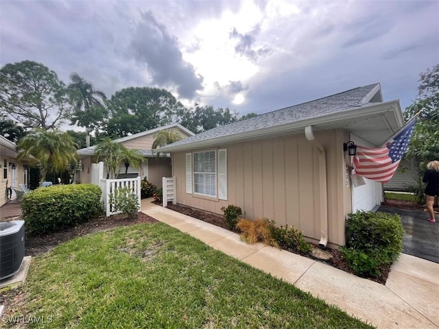 view of front of property with cooling unit and a front yard