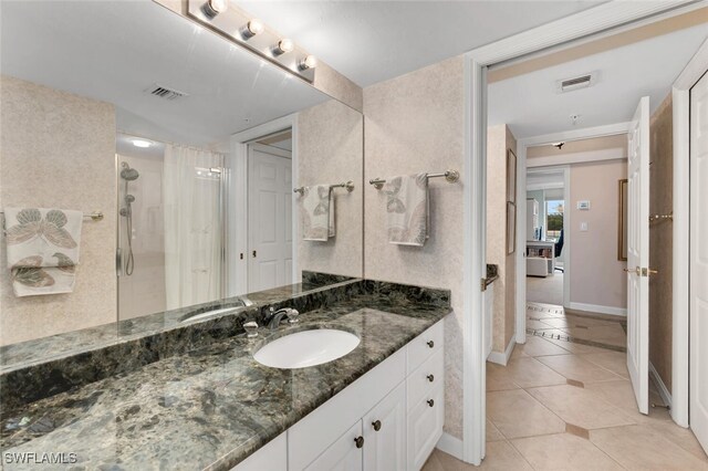 bathroom with tile patterned flooring, vanity, and an enclosed shower