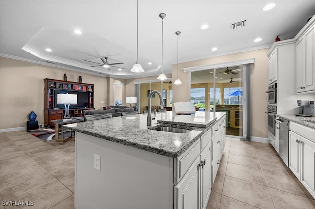 2616 Malaita Ct, Cape Coral, FL 33991 - kitchen with light stone counters, a kitchen island with sink, sink, pendant lighting, and white cabinetry