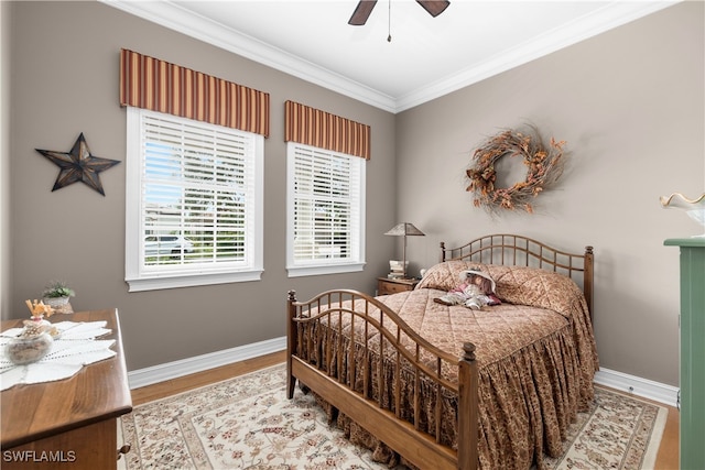 bedroom featuring wood-type flooring, ceiling fan, and crown molding