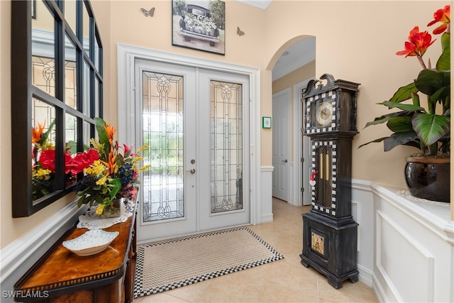 tiled foyer entrance featuring french doors and crown molding