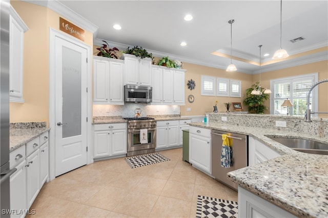 kitchen featuring ornamental molding, stainless steel appliances, hanging light fixtures, sink, and white cabinets