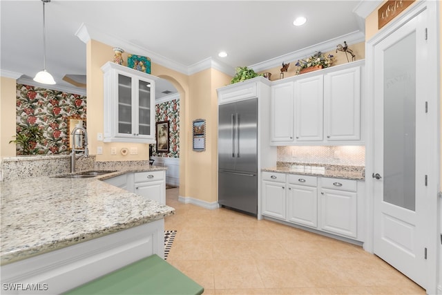 kitchen featuring stainless steel built in fridge, sink, ornamental molding, pendant lighting, and white cabinetry