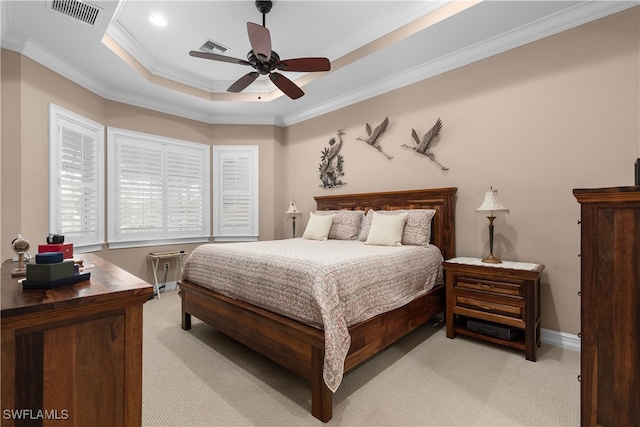 bedroom featuring ornamental molding, light carpet, ceiling fan, and a tray ceiling