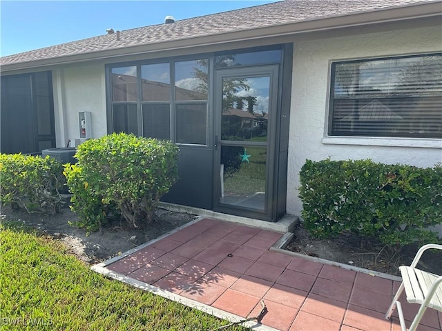 doorway to property featuring cooling unit and a patio area