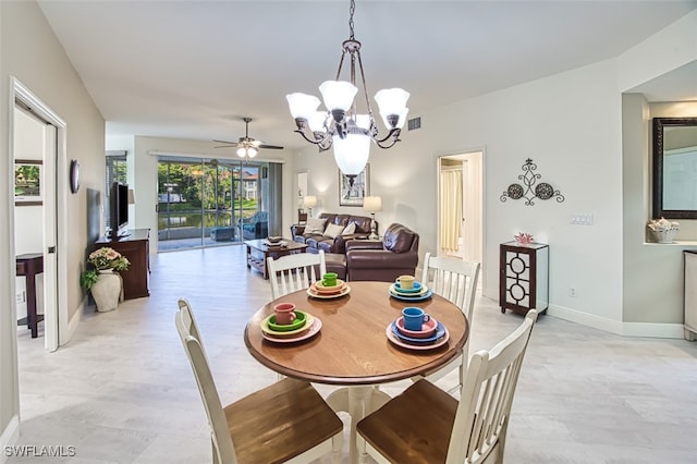 dining space featuring ceiling fan with notable chandelier