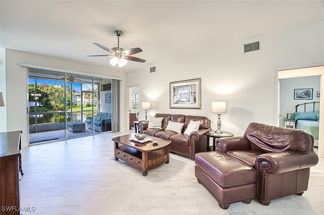 living room with ceiling fan and light hardwood / wood-style flooring