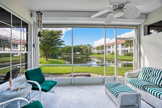 sunroom featuring a water view and ceiling fan