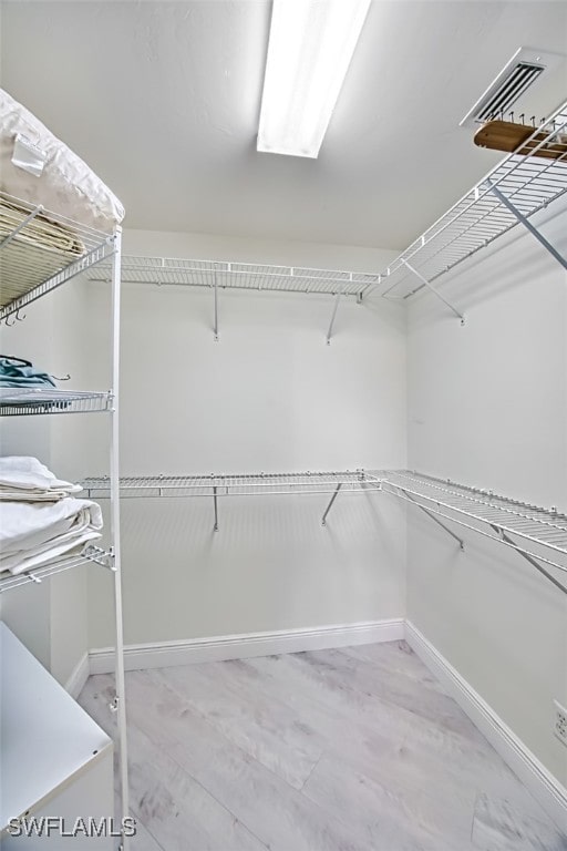 spacious closet with light hardwood / wood-style flooring