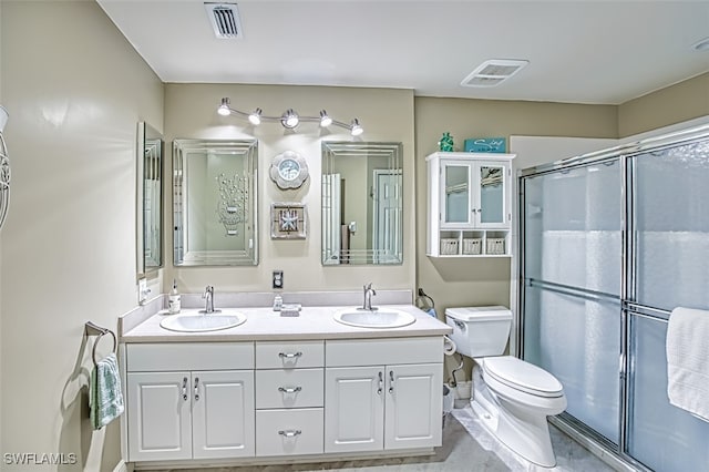 bathroom with a shower with shower door, vanity, and toilet