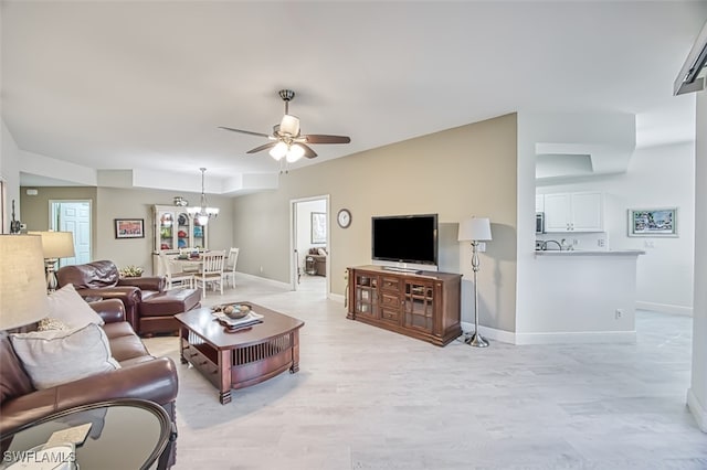 living room featuring ceiling fan with notable chandelier