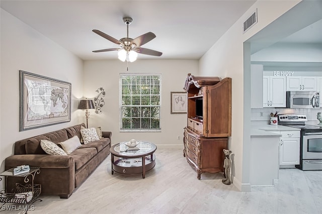 living room featuring ceiling fan and light hardwood / wood-style flooring