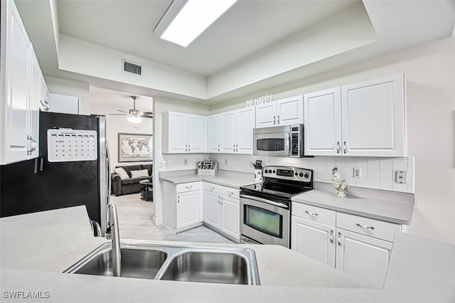 kitchen with backsplash, appliances with stainless steel finishes, sink, and white cabinets