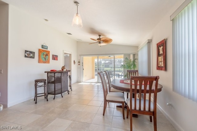 dining room with ceiling fan, lofted ceiling, and light tile patterned flooring