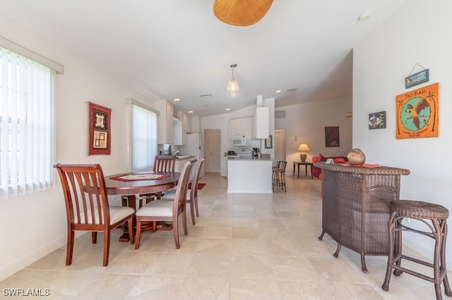 dining room featuring light tile patterned floors and vaulted ceiling