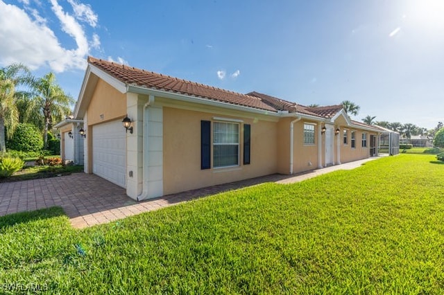 view of side of home featuring a garage and a lawn