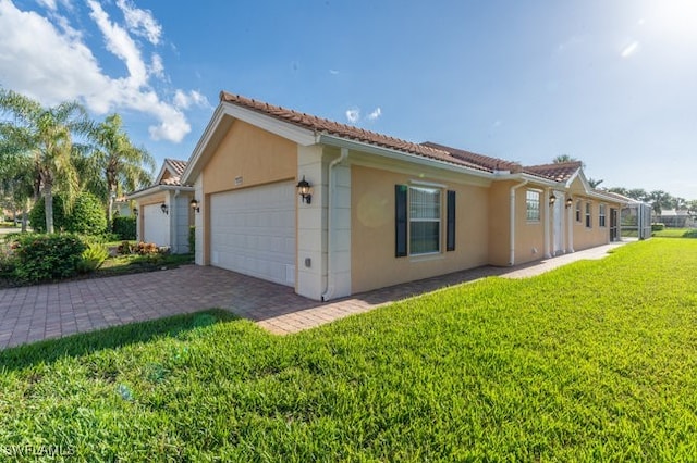 view of side of property featuring a garage and a lawn