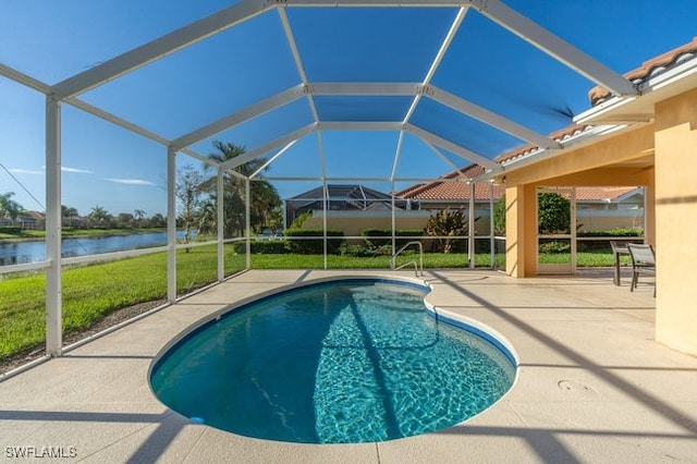 view of pool featuring a lawn, glass enclosure, a patio area, and a water view