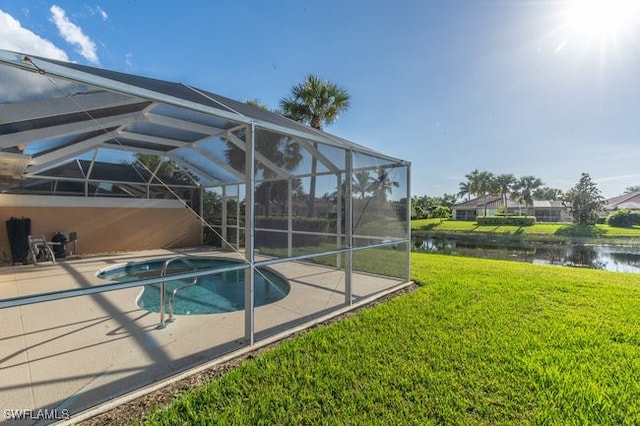 view of swimming pool featuring a lawn, glass enclosure, and a water view