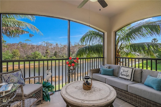 sunroom / solarium featuring a water view, ceiling fan, and a healthy amount of sunlight