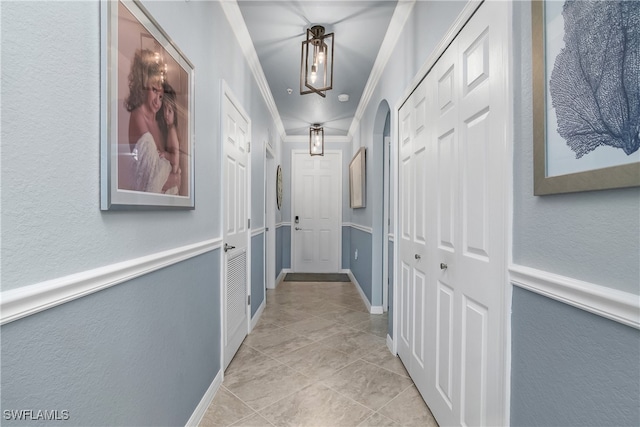 hall featuring crown molding and light tile patterned floors