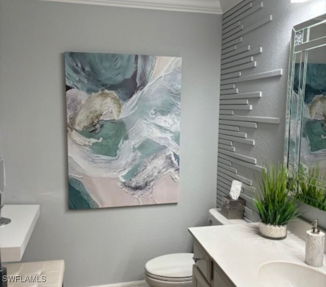 bathroom featuring vanity, toilet, and ornamental molding