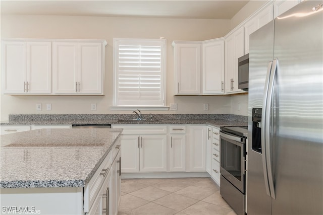 kitchen with white cabinetry, sink, light stone counters, and stainless steel appliances