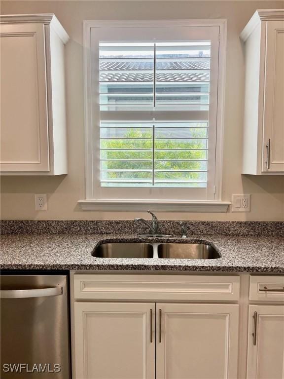 details featuring dishwasher, sink, light stone countertops, and white cabinets