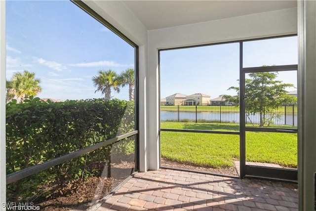 unfurnished sunroom featuring a water view