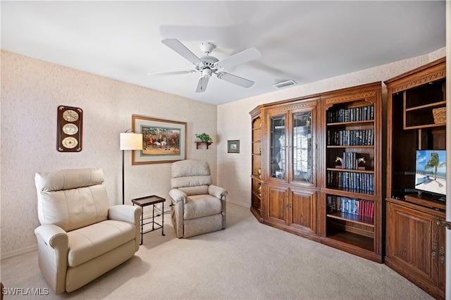 living area featuring ceiling fan and light colored carpet