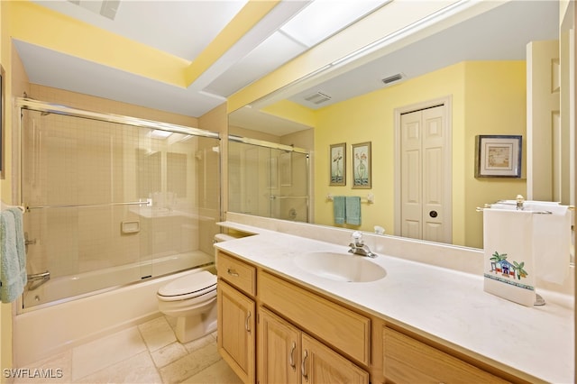 full bathroom featuring combined bath / shower with glass door, tile patterned floors, vanity, and toilet