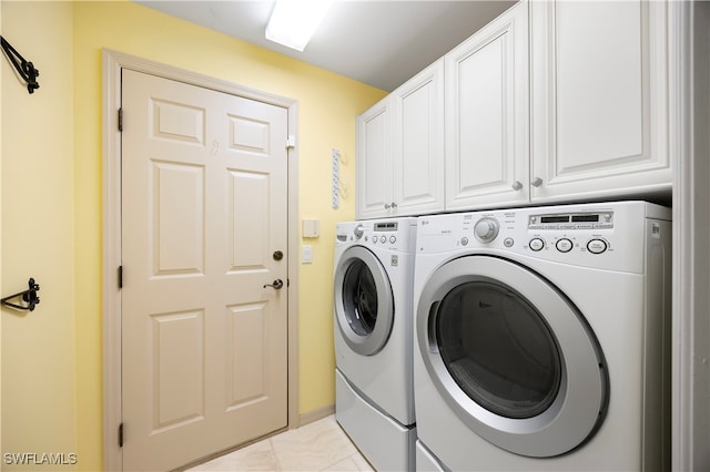 clothes washing area featuring cabinets, independent washer and dryer, and light tile patterned floors